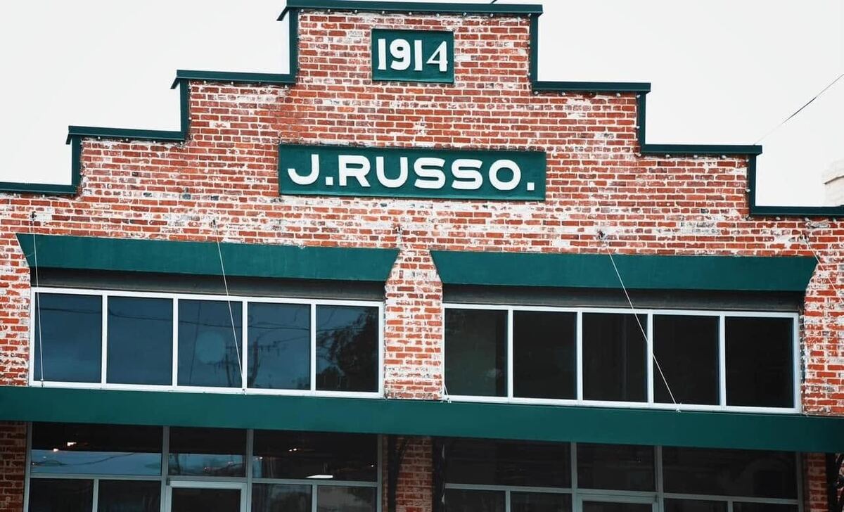 The brick facade of The Russo in downtown Abbeville, with J. Russo and 1914 lettered on green panels above the storefront windows.